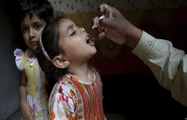 A health worker gives polio vaccine to a girl in Lahore, Pakistan, April 9, 2018.